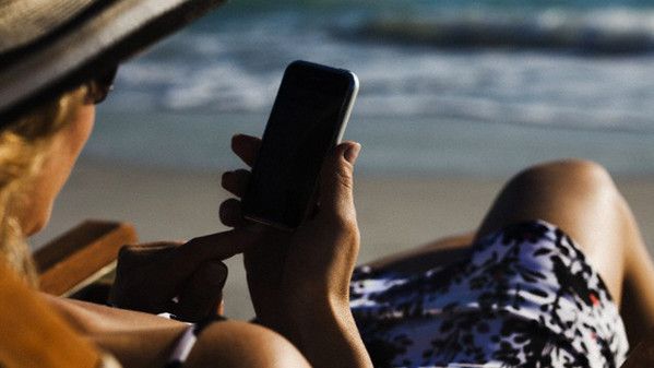 Woman text messaging with smartphone at beach