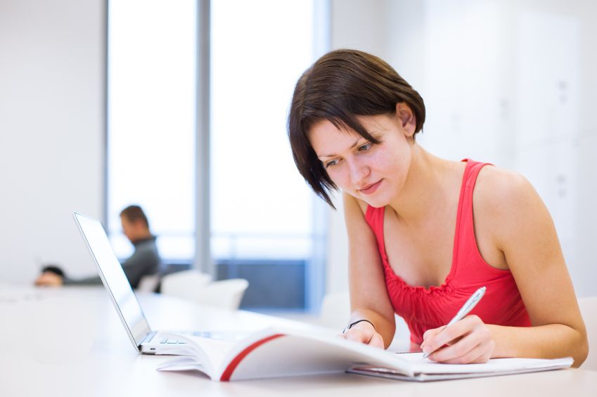 Pretty, young college student studying in the library/a study ro